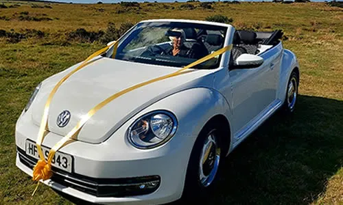 VW Beetle convertible in profile with the soft top down.