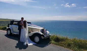 Two of the fleet's vintage cars lined up, ribbons fitted, ready for a wedding day.