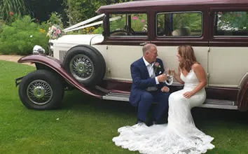 A vintage Beauford parked at a country wedding venue, ribbon dressed across the bonnet.